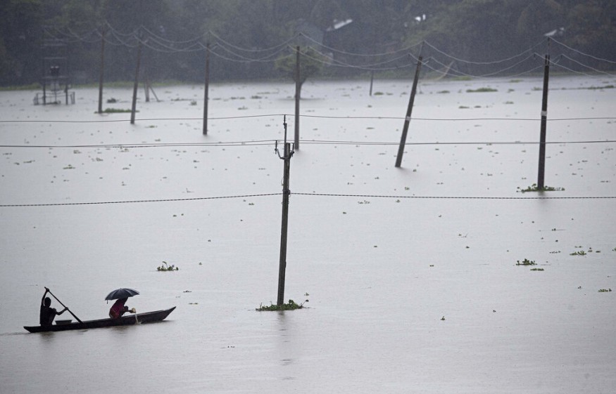 With the incessant monsoon rains during the past few days, the flood situation in Assam is worsening each passing day with 704 villages in 16 districts being inundated, affecting 2.53 lakh people while the Brahmaputra is flowing above the danger level at many places in nine districts. Villagers cross floodwaters on a country boat in Morigaon district of Assam. (Image: AP)